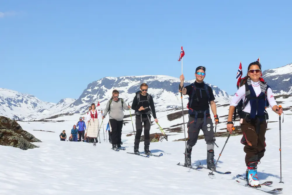skigåere med bunad og flagg