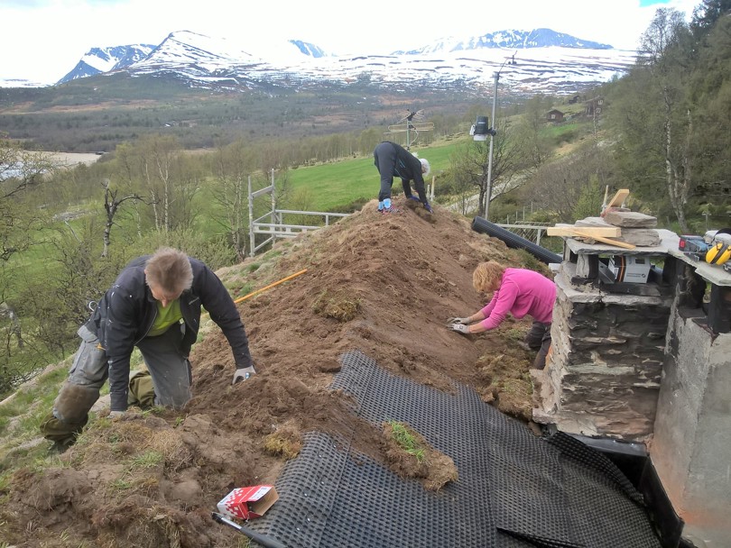 Tre personer på dugnad, som driver og graver i et torvtak