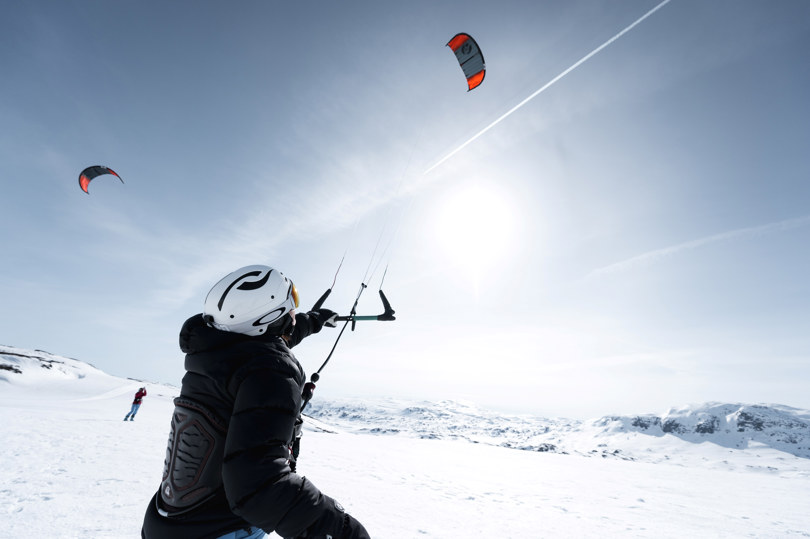 Person i vinterlandskap med kite.