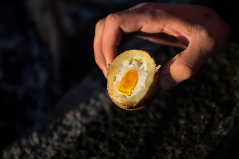 Egg stekt i hulet ut potet på bål