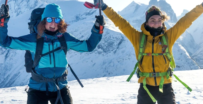To ungdom på skitur med armene i været