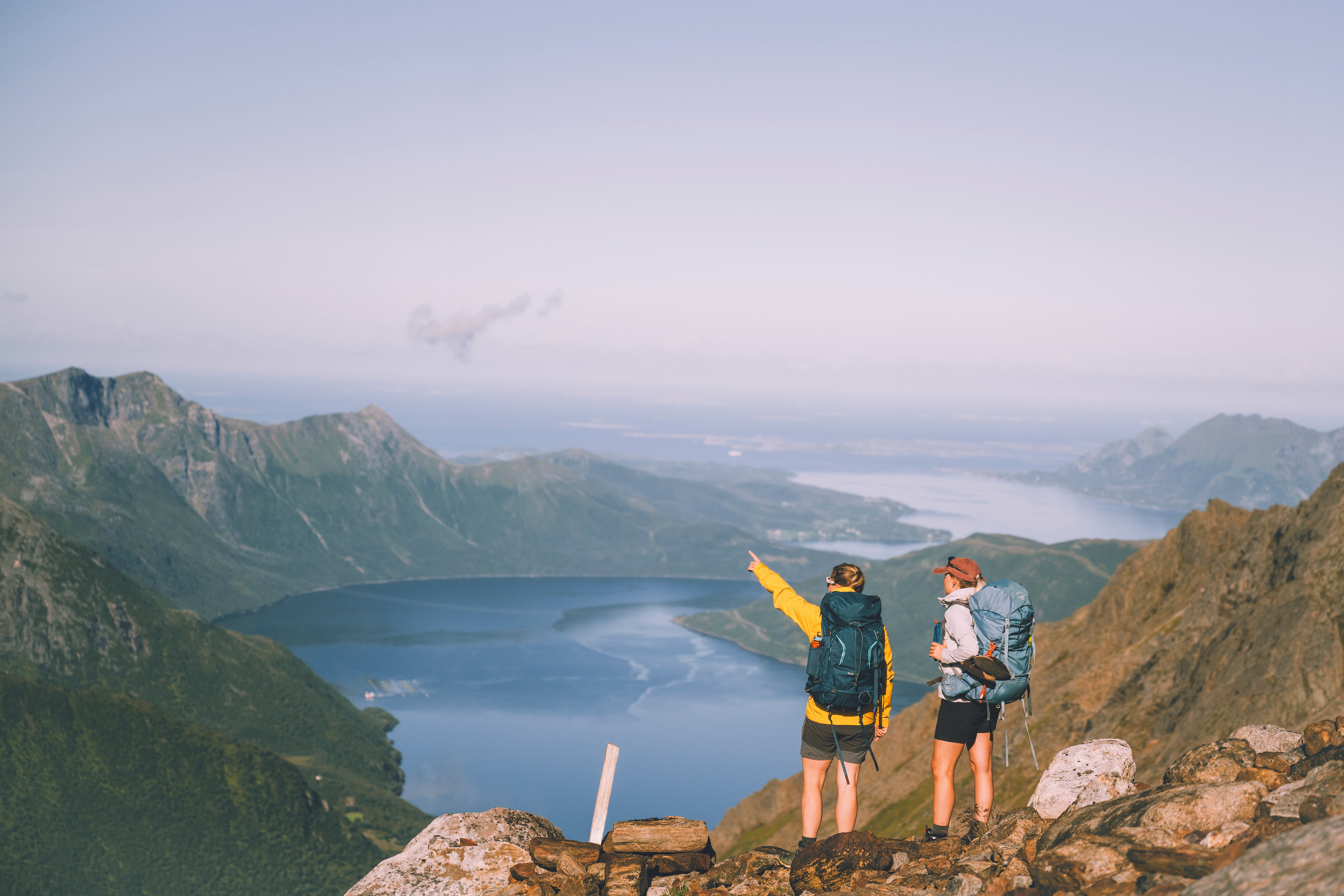 To damer ser utover vakker utsikt, fjell og fjord