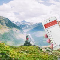 Telefonskjerm med betalingsapp foran flott fjellandskap