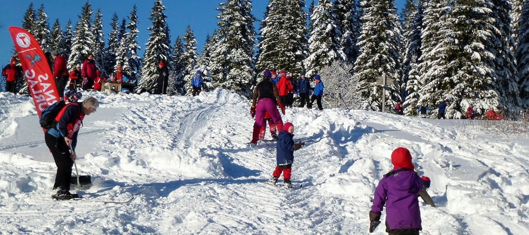 Barn leker på ski i akebakke
