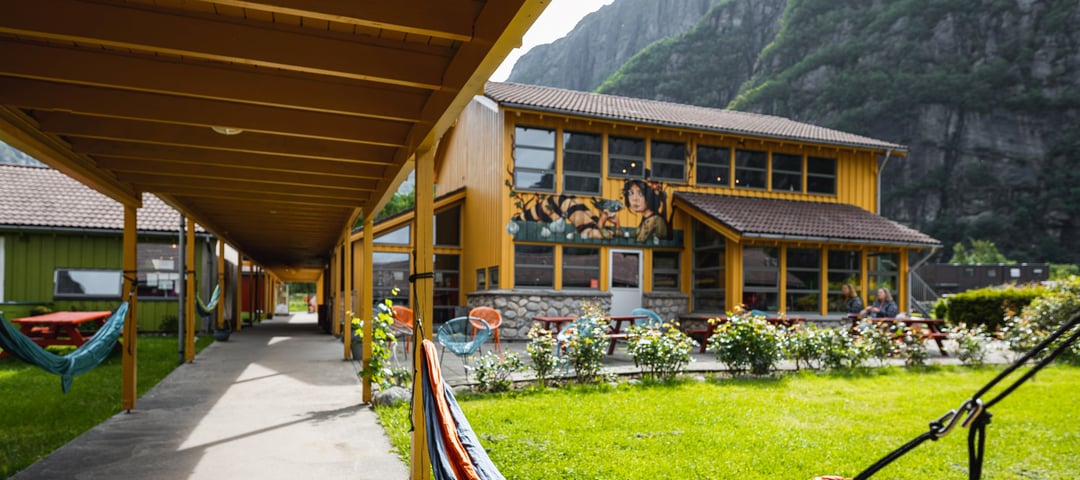 Hengekøye som er hengt opp i svalgangen inn til resepsjonen av en fargerik turisthytte.