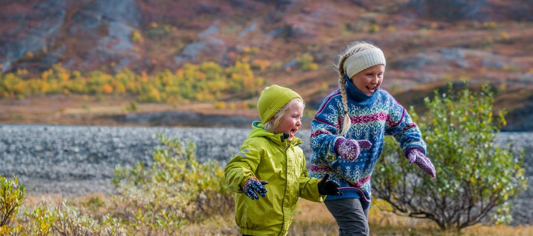 To glade barn løper ute i naturen