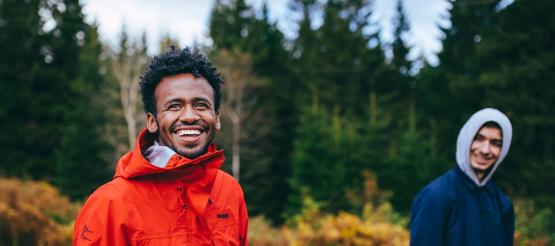 To smilende menn går tur i skogen