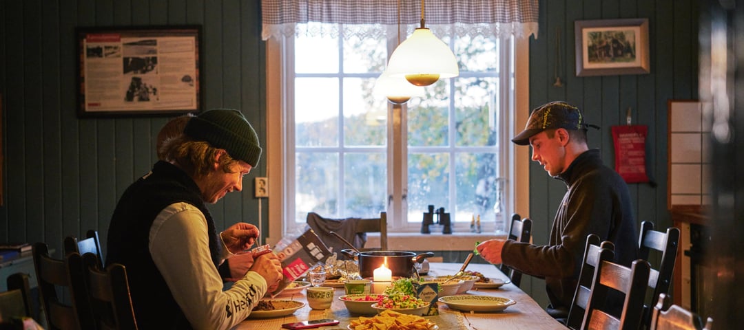 Personer som sitter ved et spisebord på en hytte.