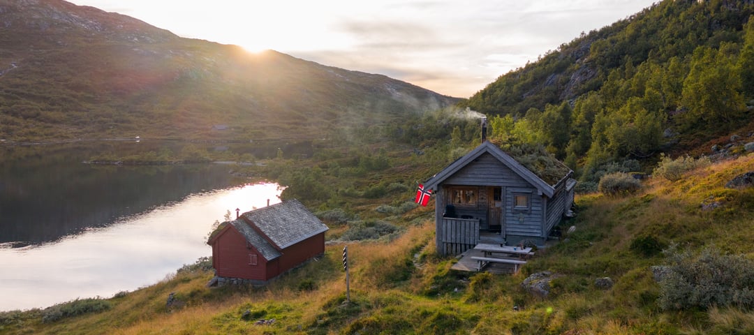 Hytte med røyk ut av pipen i høstfjellet.