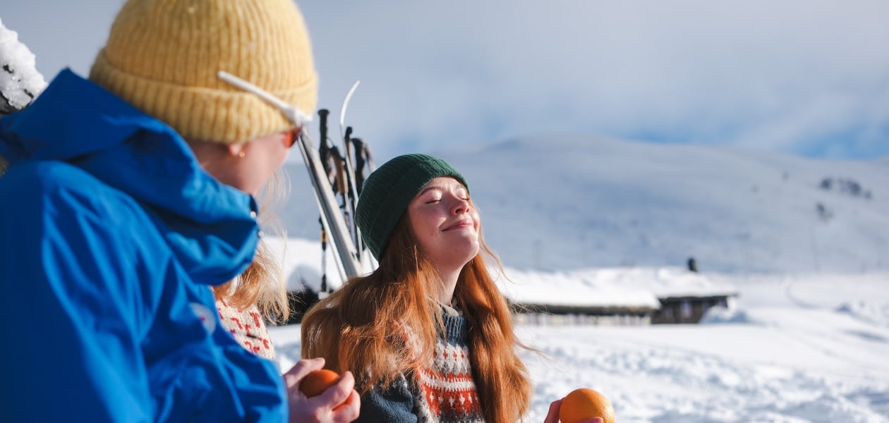 Dame som holder en appelsin og soler seg
