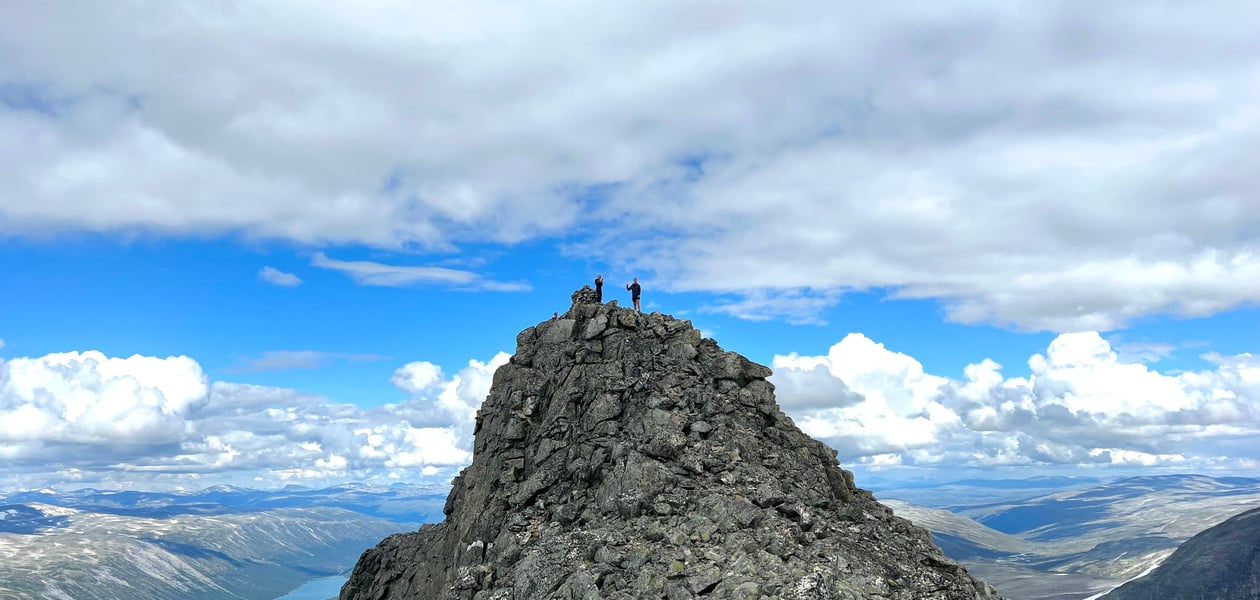 To personer som står på en fjelltopp