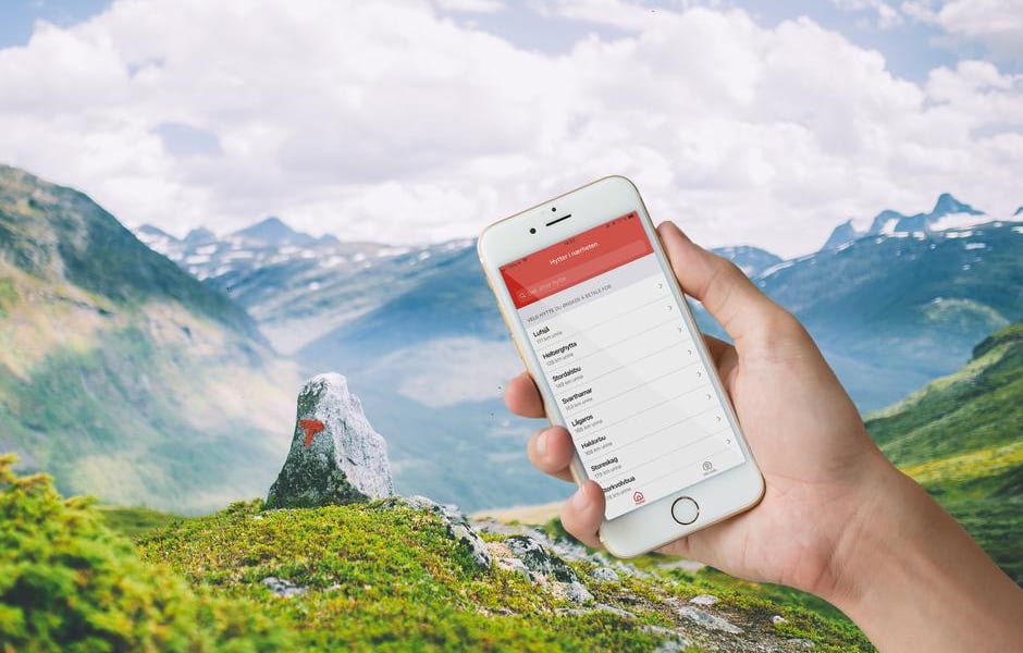 Telefonskjerm med betalingsapp foran flott fjellandskap
