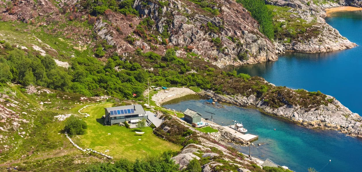 Dronefoto av hytte ved sjøen