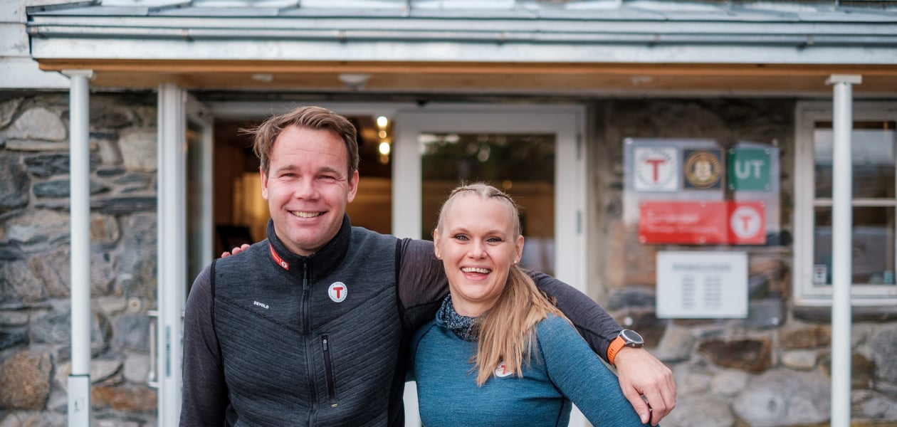 En mann og en kvinne holder rundt hverandre utenfor en inngang til et Tursenter.