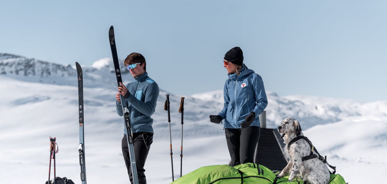 Foto. To skigåere med pulk. Blå himmel og fjell.