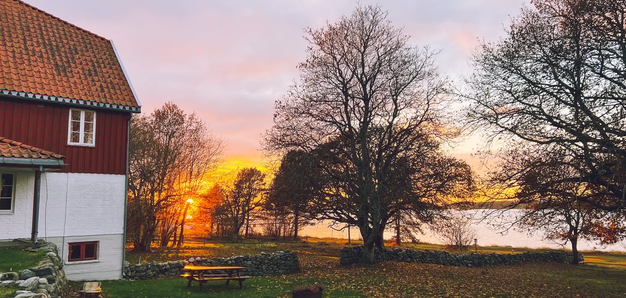 En rødmalt hytte i solnedgang