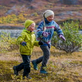To glade barn løper ute i naturen