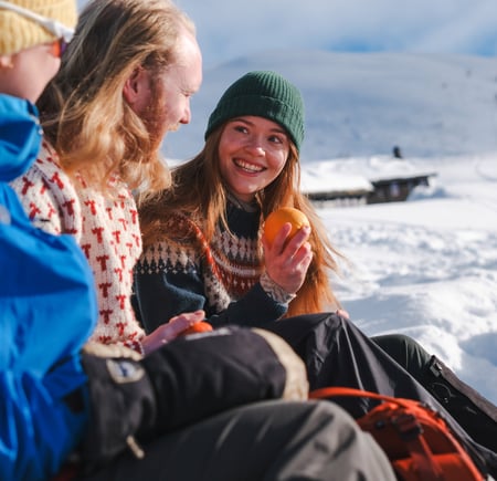 en gruppe mennesker som sitter på et snødekt fjell