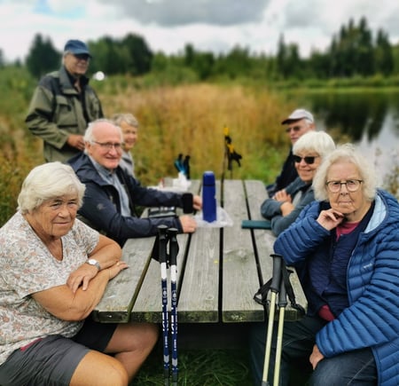 Eldre mennesker sitte på en rastebenk