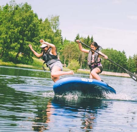 Ungdommer i packraft på stille vann