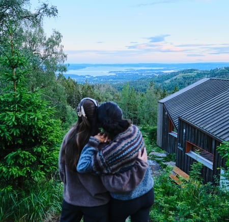 to personer står og se på utsikt ved DNT-hytte