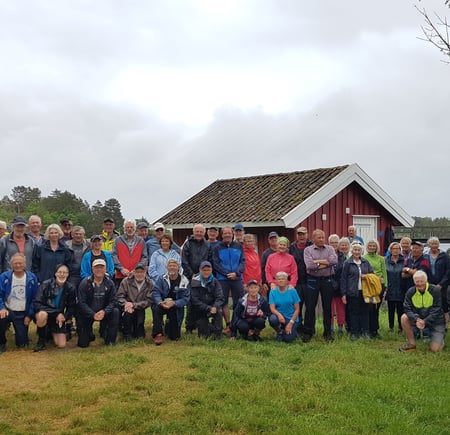 Mange mennesker står foran lite hus