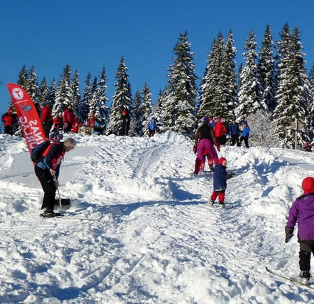 Barn leker på ski i akebakke