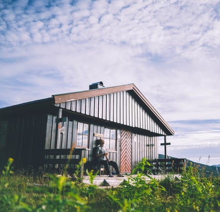 Brun hytte i grønne omgivelser