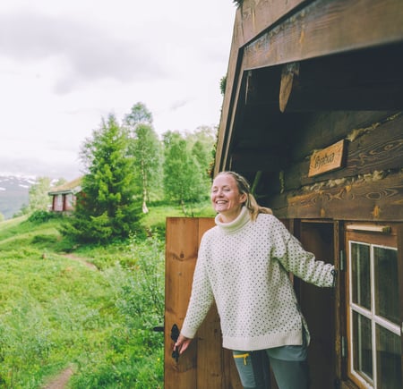 A woman opening a door in a cabin