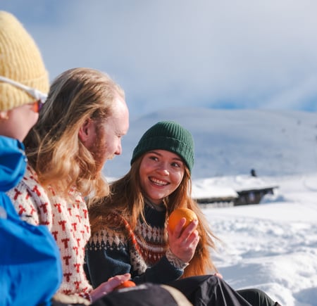 en gruppe mennesker som sitter på et snødekt fjell