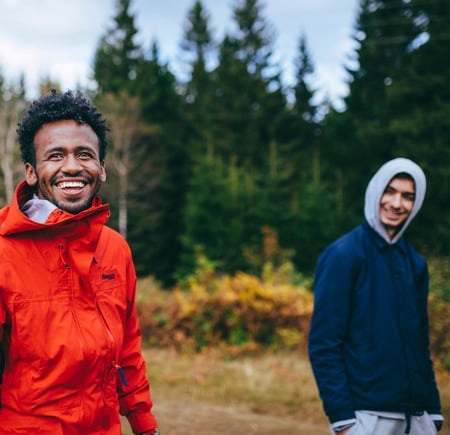 To smilende menn går tur i skogen