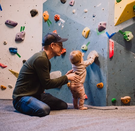 En mann og en baby som ser på en klatrevegg