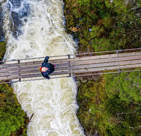 En person som står på en hengebro