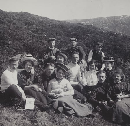 Historisk foto i svart-hvitt av pent kledd vennegjeng på tur i Byfjellene i 1908.