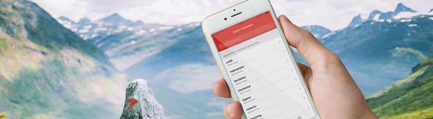 Telefonskjerm med betalingsapp foran flott fjellandskap