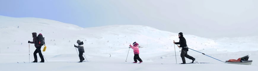 Familie på skitur i finvær