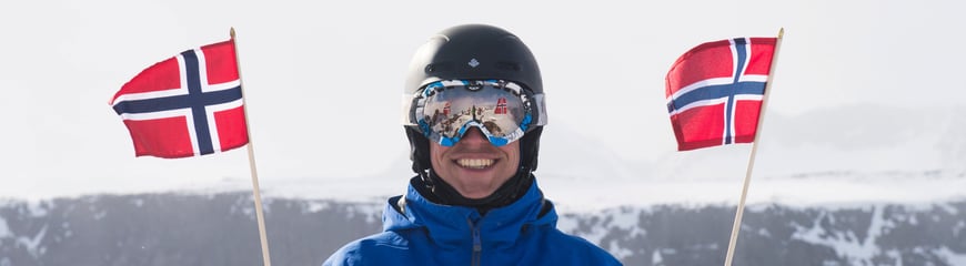 Morten F. Smedsrud jubler med norske flagg på toppen av Rasletind. 