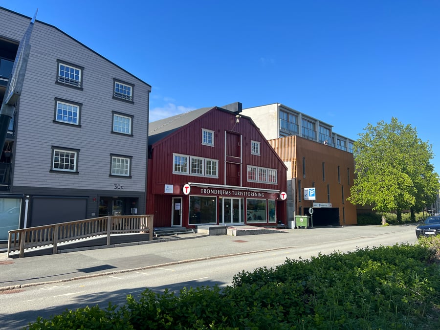 Fasadene på en rekke bygninger i en gate i Trondheim. Den røde bygningen i midten er Turisforeningens lokaler. 