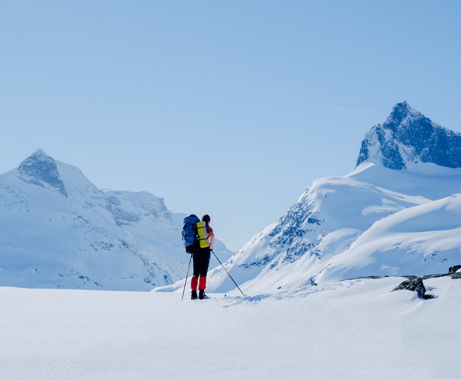 Dame som står på ski og ser på et fjell