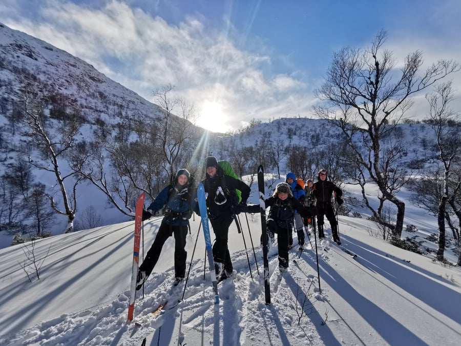 Ungdommer på skitur i sol.