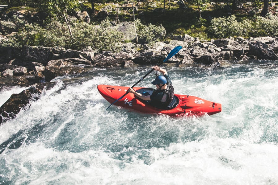 Person som padler i en stri elv.