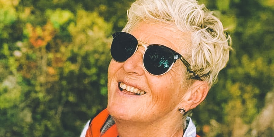 Blid dame med solbriller og rød turledervest