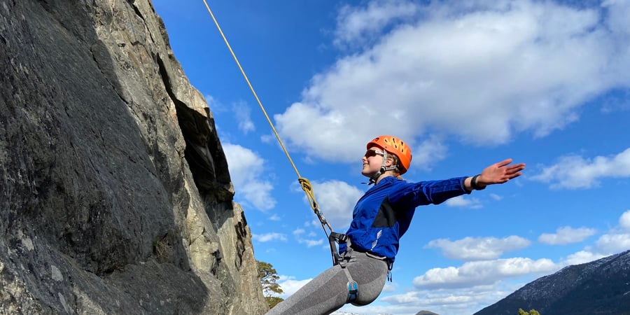 Ung fjellklatrer henger i fjellvegg