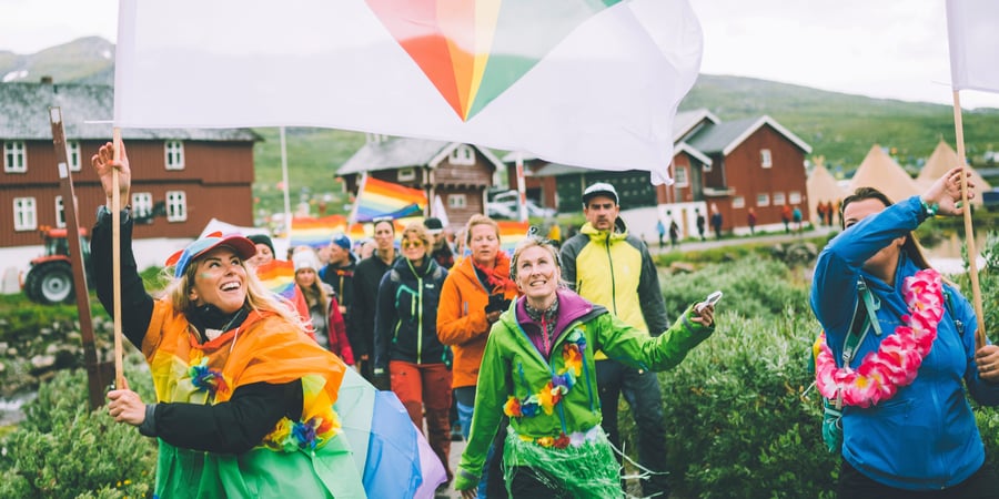 Travelt utenfor inngangen til hytta, med ski, akebrett, barn og voksne