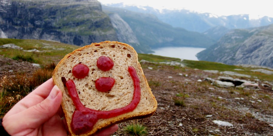 Brødskive med smilefjes. Fjellutsikt i bakgrunnen.