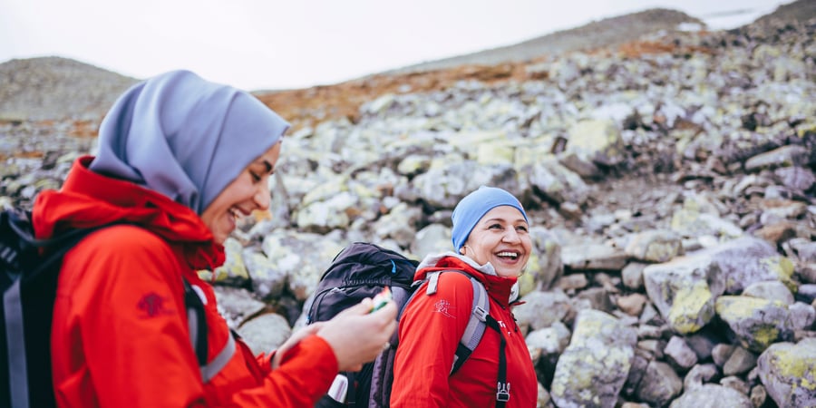 To kvinner med turlederjakker i fjellet