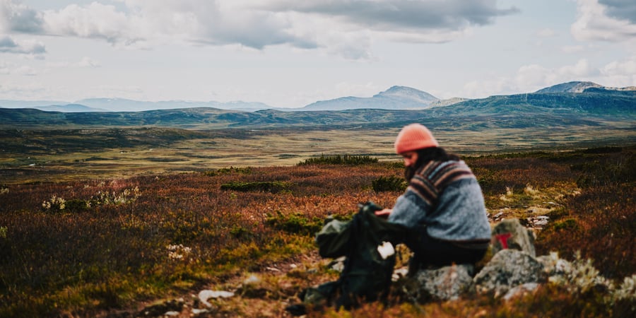 Lady with a orange hat walking in the mountains