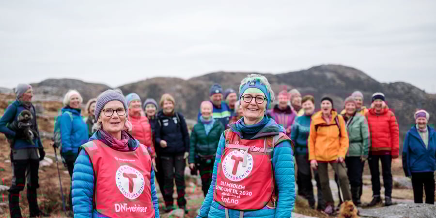 Bilde av to damer i rød T-vest foran et turfølge.