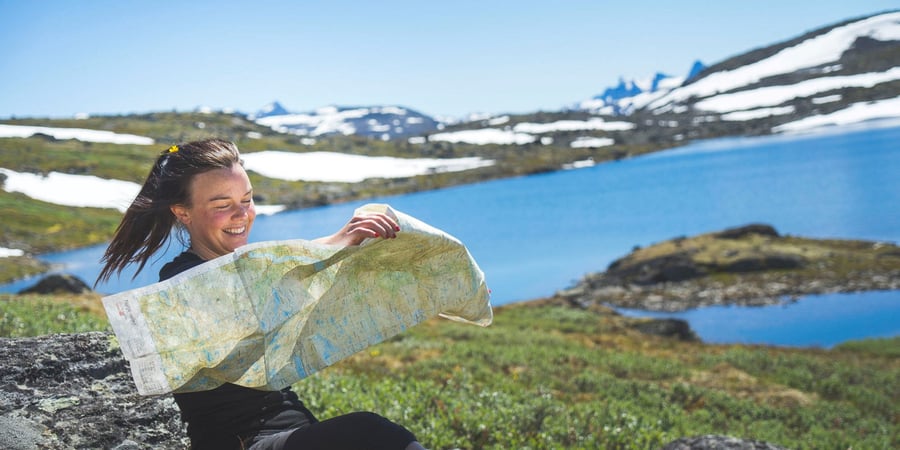 Dame med kart i fjellet