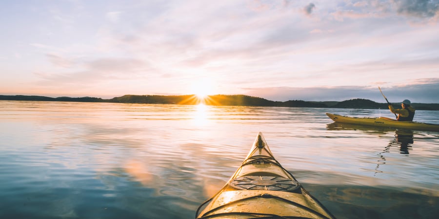 Kayak, solnedgang, blikkstille vann